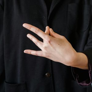 Close-up of a person's hands in a meditative mudra position.
